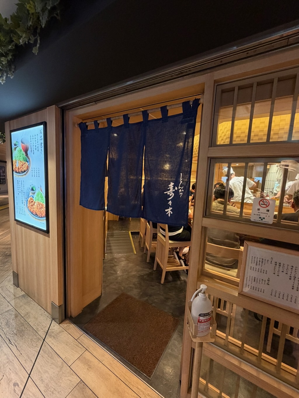 壽壽木炸豬排的暖簾入口，藍布白字寫著「とんかつ 寿々木」