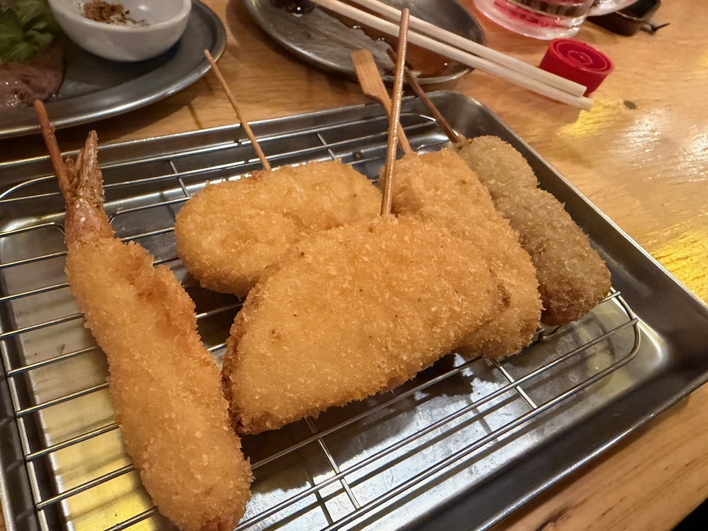 串炸田中的炸物拼盤,金黃酥脆的串物擺在鐵網上