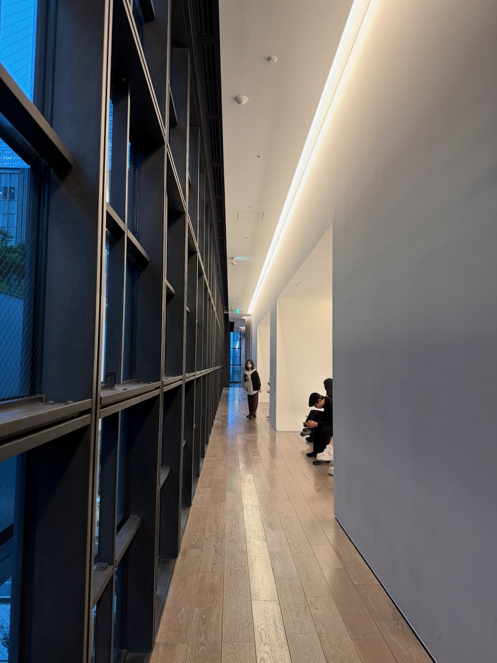 Artizon Museum 內部，臨窗的深色書架與木地板長廊